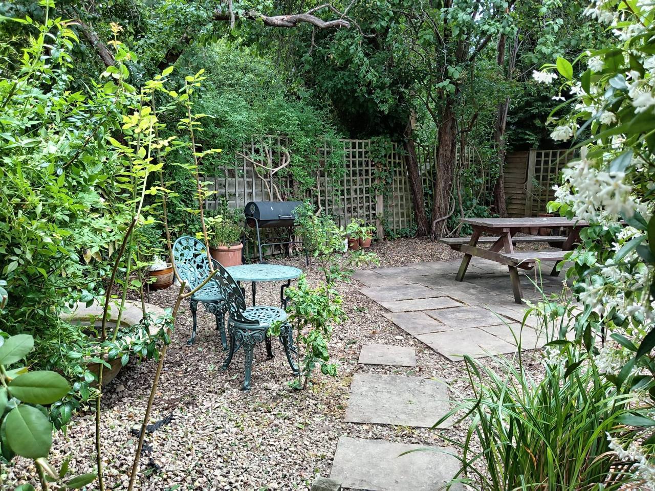 Beautiful maintained garden in North London by H&O Gardening — gravel patio with bistro seating